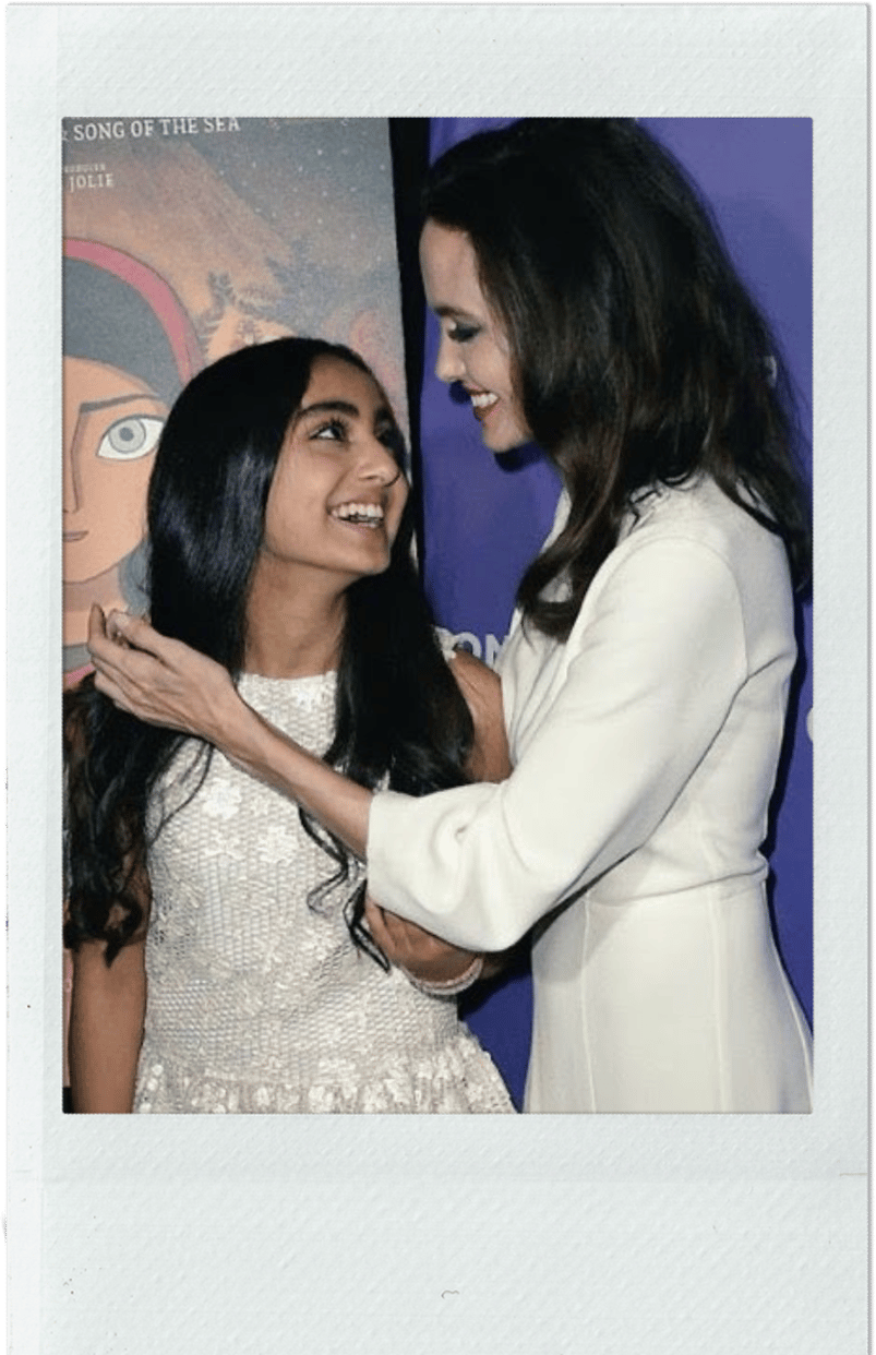 A girl and a woman wearing look at each other smiling 