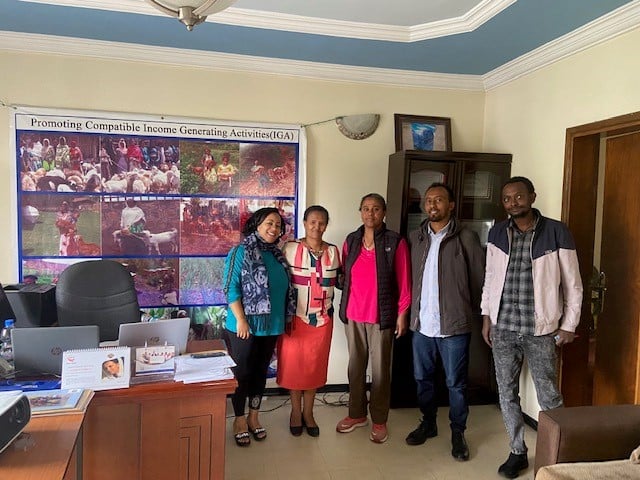 Five Union of Ethiopian Women and Children Associations staff members stand together in their office.