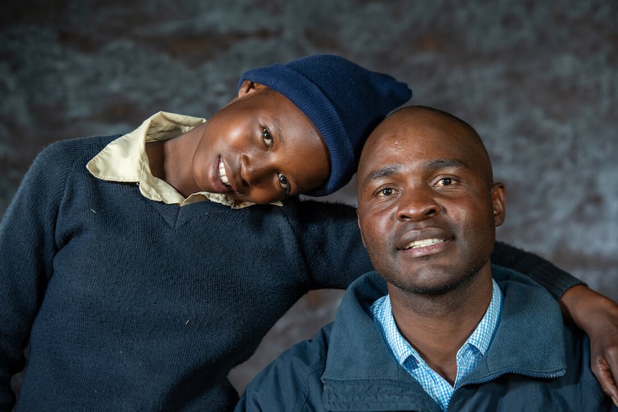 Young woman and her father pose for portrait after sharing their story with journalist.